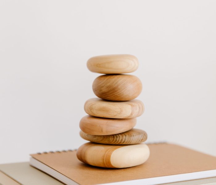 Stack of round polished wood chunks and beige notebooks